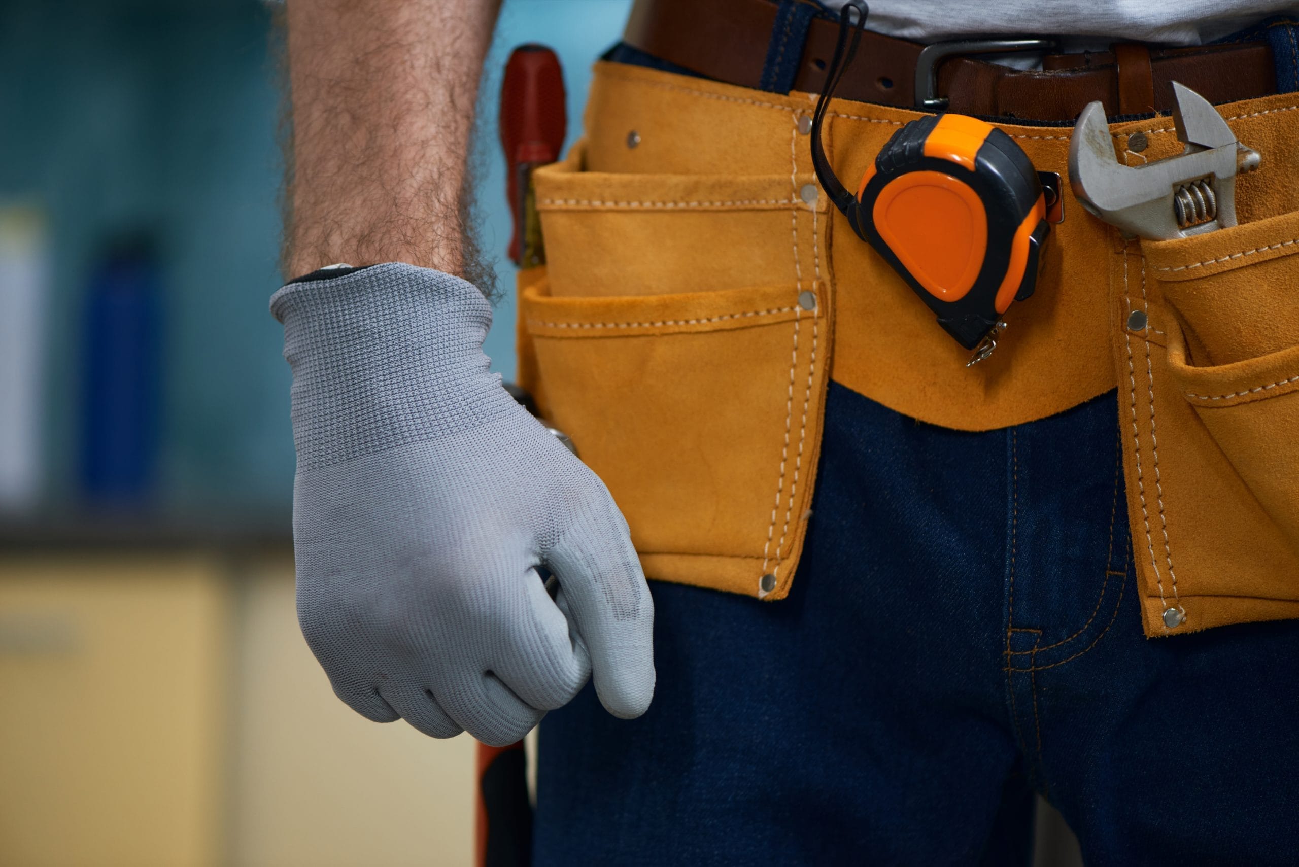 Close up of repairman wearing a tool belt with various tools